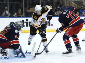 David Pastrnak of the Boston Bruins shoots a shot on Henrik Lundqvist of the New York Rangers defended by Brady Skjei during the third period at Madison Square Garden on October 26, 2016 in New York City. (Michael Reaves/Getty Images)