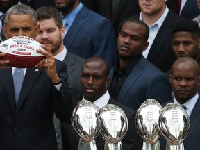 U.S. President Barack Obama holds up a football presented to him as a gift by Patriots owner Robert Kraft while Obama welcomed the National Football League Super Bowl champion, the New England Patriots, to the White House April 23, 2015 in Washington, DC. (Win McNamee/Getty Images)