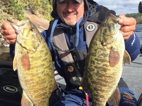 Sudbury Star outdoors columnist Frannk Clark shows a pair of healthy smallmouth bass he caught on a local lake Monday. Dropping temperatures mean the bass bite is on.  Supplied Photo