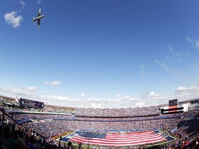 A giant flag covers the field as a C-130 flies overhead during pre-game ceremonies before the Miami Dolphins and the Buffalo Bills football game at Ralph Wilson Stadium on Nov. 8, 2015 in Orchard Park, New York. (Brett Carlsen/Getty Images)