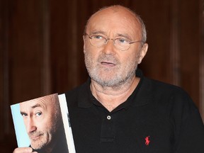 Phil Collins poses with a copy of his autobiography Not Dead Yet  on October 18, 2016 in London, England. (Photo by Chris Jackson/Getty Images)