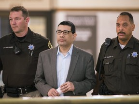 In this Sept. 27, 2016 photo, Anthony Garcia is led by deputies at the Douglas County Court in Omaha, Neb. Closing arguments are taking place Tuesday, Oct. 25, 2016, in his trial. Garcia, a former doctor, is accused of killing four people with ties to the Creighton medical school that fired him in 2001. (AP Photo/Nati Harnik)
