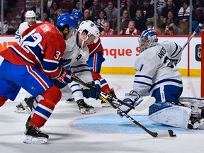 Maple Leafs’ Morgan Rielly defends the puck near goaltender Frederik Andersen during Saturday night’s game against the Canadiens at the Bell Centre in Montreal. (GETTY IMAGES)