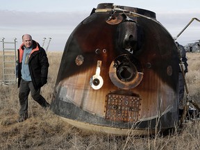 A Russian Soyuz MS space capsule rests on the ground after landing as a rescue helicopter lands nearby, about 150 kms (90 miles) southeast of the Kazakh town of Dzhezkazgan on Oct. 30, 2016. (DMITRI LOVETSKY/AFP/Getty Images)