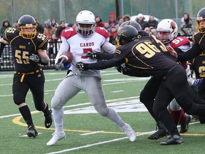 Bankamina N'Galamulume, second left, of St. Charles Cardinals, is gang tackled by Lively Hawks defenders during senior boys semifinal football action at James Jerome Sports Complex in Sudbury, Ont. on Saturday October 29, 2016. John Lappa/Sudbury Star/Postmedia Network