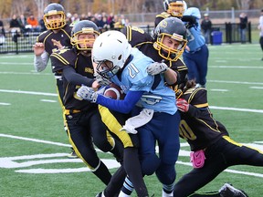 Ben Larsen, middle, of St. Benedict Bears, is tackled by Lively Hawk defenders during the junior boys high school football final at James Jerome Sports Complex in Sudbury, Ont. on Saturday October 29, 2016. The Bears won 16-6. John Lappa/Sudbury Star/Postmedia Network