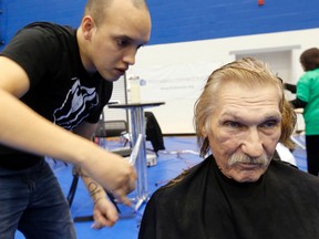 Volunteer Matthew Genser cuts Peter Jaudzems hair at the annual Homeless Connect Toronto event on Sunday. (MICHAEL PEAKE, Toronto Sun)