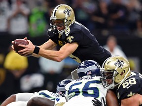 New Orleans Saints quarterback Drew Brees dives over the pile for a touchdown in the first half of an NFL game against the Seattle Seahawks in New Orleans on Oct. 30, 2016. (AP Photo/Bill Feig)