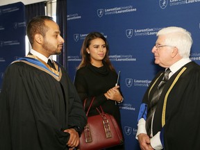 Former politician and educator Rick Bartolucci, right, chats with graduating student Hassan Alomayri, left, and his girlfriend, Ana M. Hinestroza, at a fall convocation ceremony at Laurentian University in Sudbury on Saturday. Bartolucci and Stratford Festival artistic director Antoni Cimolino received an honorary doctorate at convocation ceremonies at Laurentian. John Lappa/Sudbury Star