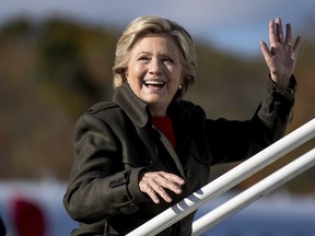 Democratic presidential candidate Hillary Clinton waves to members of the media as she boards her campaign plane at Westchester County Airport in White Plains, N.Y., Monday, Oct. 31, 2016, to travel to Cleveland for a rally. (AP Photo/Andrew Harnik)