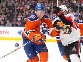 Jesse Puljujarvi battles Ryanh Dzingel for the puck during Sunday's game at Rogers Place. (The Canadian Press)