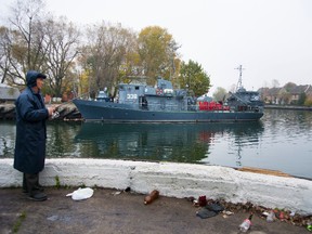 In this photo taken on Thursday, Oct. 20, 2016, a fisherman angles fish at the bay of the Russian Baltic Fleet base of Baltiysk, Russia. Despite the mounting tensions between Russia and NATO, and civil defence drills involving millions, the Russian people seem largely oblivious to a threat of a new Cold War. (AP Photo/Nataliya Vasilyeva)
