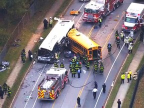 In this frame from video, emergency personnel work at the scene of a fatal school bus and a commuter bus crash in Baltimore, Tuesday, Nov. 1, 2016. (WBAL-TV via AP)