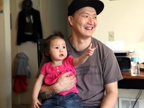 In this March 19, 2015, file photo, Korean adoptee Adam Crapser poses with daughter, Christal, 1, in the family's living room in Vancouver, Wash. Crapser, a South Korean man who was flown to the U.S. 37 years ago and adopted by an American couple at age 3 has been ordered deported back to a country that is completely alien to him.(AP Photo/Gosia Wozniacka, file)