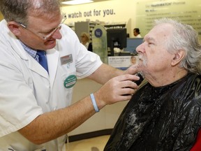 Luke Hendry/The Intelligencer
Pharmacist Evan Sullivan shaves the face of employee and prostate cancer survivor Keith Smith at the Quinte Mall Shoppers Drug Mart in Belleville Tuesday. Smith's cancer was discovered through routine testing and he urges men to seek regular screening.