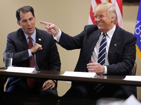 Republican presidential nominee Donald Trump (R) sits down with Wisconsin Governor Scott Walker and a group of invited small business owners for a round table meeting at the Staybridge Suites November 1, 2016 in Altoona, Wisconsin. After sitting down, Trump immediately began to talk about poll numbers and former Indiana University basketball coach Bobby Knight told a joke. (Photo by Chip Somodevilla/Getty Images)