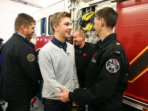 Luke Pignatelli shakes hands with the firefighters who saved his life. (DAVE ABEL, Toronto Sun)