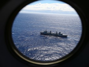 In this March 31, 2014 file photo, HMAS Success scans the southern Indian Ocean, near the coast of Western Australia, as a Royal New Zealand Air Force P3 Orion flies over, while searching for missing Malaysia Airlines Flight MH370. A fresh analysis of the final moments of doomed Malaysia Airlines Flight 370, released by the Australian Transport Safety Bureau Wednesday, Nov. 2, 2016, suggests no one was controlling the plane when it plane plunged into the ocean. (AP Photo/Rob Griffith, File)