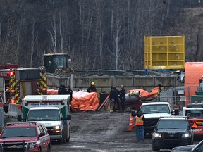 Police and fire personnel are lifted out of a tunnel as they responded to a workplace death underground at a sanitary sewer construction project in southwest Edmonton Tuesday.