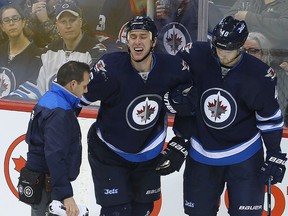 Winnipeg Jets center Shawn Matthias (c) is helped off the ice by trainer Rob Milette (l) and winger Joel Armia after sustaining a lower body injury during NHL hockey against the Washington Capitals in Winnipeg, Man. Tuesday November 01, 2016. Brian Donogh/Winnipeg Sun/Postmedia Network
