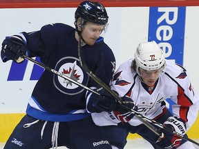 Winnipeg Jets left winger Kyle Connor (left) ties up Washington Capitals right winger T.J. Oshie during Tuesday night's game. (Brian Donogh/Winnipeg Sun)
