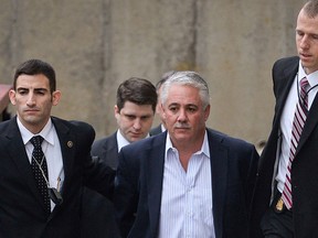 In this Dec. 9, 2015 file photo, former Suffolk County police chief James Burke is escorted to a vehicle by FBI personnel outside an FBI office in Melville, N.Y. (Steve Pfost/Newsday via AP, File)