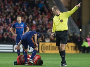 New York City FC forward David Villa stands over Toronto FC's Armando Cooper after taking down the midfielder during MLS playoff action on Sunday. (Chris Young/THE CANADIAN PRESS)