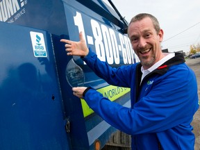 1-800-GOT-JUNK franchise owner Andrew de Boer shows off the Better Business Bureau Integrity Award, given to the company of less than 10 employees for operating with exceptional integrity to customers, employees and community, in the junk removal company's yard in London. (CRAIG GLOVER, The London Free Press)