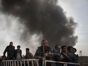 Displaced people stand on the back of a truck at a checkpoint near Qayara, south of Mosul, Iraq, Tuesday, Nov. 1, 2016. The U.N. human rights office is lauding efforts by the U.S.-led coalition in the battle against the Islamic State group in Mosul. The office in Geneva says coalition flights over Iraq have largely succeeded in preventing IS from bringing in 25,000 more civilians to the city center, where the militant group has been using people as human shields as Iraqi forces advance on Mosul. (AP Photo/Felipe Dana)