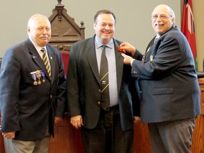 On Wednesday, Oct. 26, Legion Branch 109 Poppy Chairman Ben Prouse, right, pins the ceremonial first poppy on Goderich Mayor Kevin Morrisson’s lapel, centre, while legion President Dennis Schmidt, right, looks on. SUBMITTED