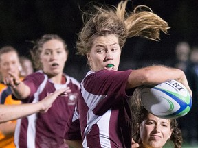 Sara Svoboda looks to offload the ball while her twin sister, Katie (far left), provides support during a recent OUA women's rugby match. (McMaster Athletics photo)