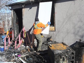 A worker boards up a rooming house at 378 Alexander Ave. last February following  a fire that claimed two lives. (Brian Donogh/Winnipeg Sun file photo)