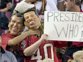 In this Nov. 12, 2000 file photo, fans, one dressed as Republican presidential candidate Texas Gov. George W. Bush, left, playfully chokes a fan dressed as Democratic presidential candidate Vice President Al Gore, during the Tampa Bay Buccaneers game against the Green Bay Packers in Tampa, Fla. (AP Photo/Steve Nesius, File)