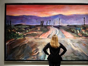 A woman looks towards a painting by Bob Dylan called "Endless Highway" on display at the exhibition called Bob Dylan The Beaten Path, at the Halcyon Gallery in London, Tuesday, Nov. 1, 2016. (AP Photo/Kirsty Wigglesworth)