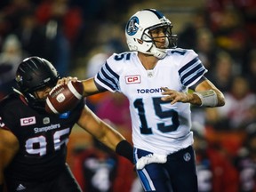 Toronto Argonauts quarterback Ricky Ray looks for a receiver as Calgary Stampeders' Zach Minter defends during first half CFL football action in Calgary, Friday, Oct. 21, 2016.THE CANADIAN PRESS/Jeff McIntosh