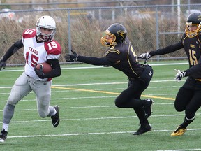 Matt Bell, left, of St. Charles Cardinals, eludes Ryan Rouleau, middle, and Russell Hopkins, of the Lively Hawks, during senior boys semifinal football action at James Jerome Sports Complex in Sudbury, Ont. on Saturday October 29, 2016. The Cardinals meet the Lo-Ellen Park Knights in the city final Friday at 7:30 p.m. at James Jerome. John Lappa/Sudbury Star/Postmedia Network