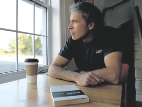 Tim Miller/The Intelligencer
Author Ken Murray sits in a Bloomfield cafe with a copy of his debut novel Eulogy on Wednesday Belleville. Murray will be speaking at the Belleville Public Library this Saturday at 2:30 p.m.