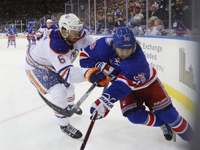Adam Larsson checks Rangers forward Mats Zuccarello during Thursday's game in New York. (Getty Images)