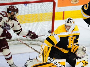 Logan DeNoble of the Petes attempts to deflect the puck past Kingston Frontenacs goalie Jeremy Helvig during OHL action Thursday night at the Memorial Centre in Peterborough. (Clifford Skarstedt/Postmedia Network)