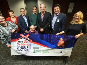 Cam Tait (centre) and representatives from the Edmonton Sun, Christmas Bureau of Edmonton, the Stollery Children’s Hospital Foundation, the Sign of Hope campaign operated by Catholic Social Services, and Adopt-A-Teen pose for a photo as this year's ATCO Edmonton Sun Christmas Charity Auction comes to a close, in Edmonton on Thursday Nov. 3, 2016. DAVID BLOOM/Postmedia