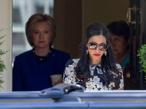 In this June 10, 2016 file photo, top Clinton aide Huma Abedin walks ahead of Democratic presidential candidate Hillary Clinton following a private meeting at Clinton's home in Washington. Clinton and Huma discussed sending a secure cell phone to the secretary of state by FedEx or a personal courier, according to emails released Thursday, Nov. 3, 2016. The State Department said either approach would have been acceptable, if the telephone was rendered inoperable for the journey. (AP Photo/J. Scott Applewhite, File)