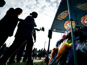 Local residents place flowers on a memorial outside the Urbandale Police Department, Wednesday, Nov. 2, 2016, in Urbandale, Iowa. Urbandale officer Justin Martin and Des Moines officer Sgt. Anthony Beminio were ambushed and fatally shot in separate attacks Wednesday as they sat in their patrol cars, authorities said. (AP Photo/Charlie Neibergall)