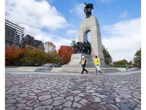 Workers inspect the stonework and polymer sand filler that surrounds the National War Memorial. The newly refurbished memorial was reopened to the public today. WAYNE CUDDINGTON / POSTMEDIA