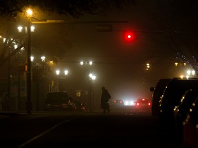 A pedestrian makes their way through the fog along 104 Street near 83 Avenue, in Edmonton on Wednesday Nov. 2, 2016. David Bloom/Postmedia