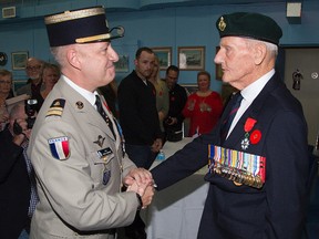 Col. Roger Vandomme, deputy defence attache for France, presents his country?s National Order of the Legion of Honour, shown at left, to 91-year-old William Donald (Pete) Schussler Friday in London, in recognition of Schussler?s efforts in the liberation of France in 1945. (DEREK RUTTAN, The London Free Press)