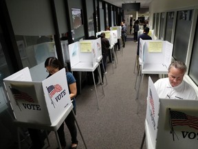 Paul Mosher, at right, votes early at the Santa Clara County Registrar of Voters, Friday, Nov. 4, 2016, in San Jose , Calif. (AP Photo/Marcio Jose Sanchez)