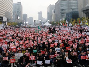 South Korean protesters stage a rally calling for South Korean President Park Geun-hye to step down in downtown Seoul, South Korea, Saturday, Nov. 5, 2016. Tens of thousands of South Koreans are expected to march in Seoul to demand Park's resignation on Saturday, a day after she took blame for a "heartbreaking" scandal and rising suspicion that she allowed a mysterious confidante to manipulate power from the shadows. The signs read "Park Geun-hye should step down." (AP Photo/Ahn Young-joon)