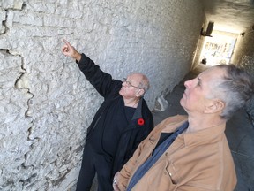Bernard Boudreau (left ) and his neighbor, Zubin Gillespie, examine a crack on the northeast side of Boudreau's Front Street property. The city has ordered Boudreau to vacate the property by Nov. 11, due to concerns about the structural integrity of the building