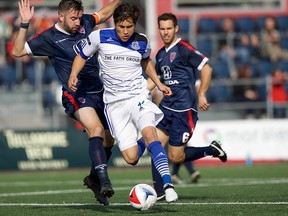 FC Edmonton midfielder Dustin Corea steps by Indy Eleven midfielder Sinisa Ubiparipovic as Dylan Mares looks on in the North American Soccer League semifinal at Carroll Stadium in Indianapolis, Indiana on Saturday, Nov. 5, 2016.