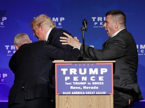 Members of the Secret Service rush Republican presidential candidate Donald Trump off the stage at a campaign rally in Reno, Nev., on Saturday, Nov. 5, 2016. (AP Photo/John Locher)